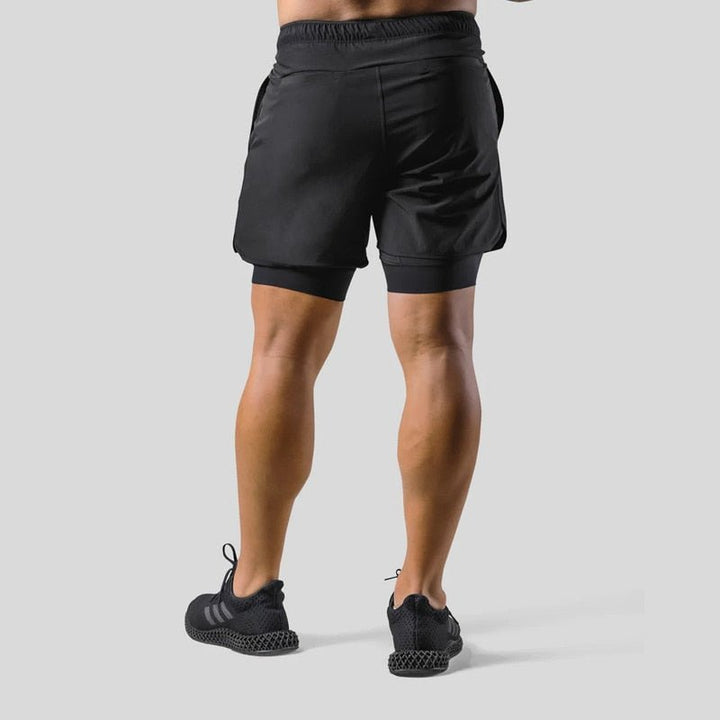 Model toont heren 2-in-1 sportshorts in Zwart/Oranje