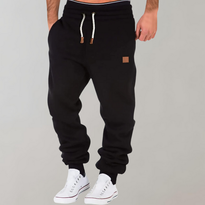 Heren joggingbroek, comfortabel met baggy pasvorm, zacht materiaal, donkere kleur, sportief en elegant