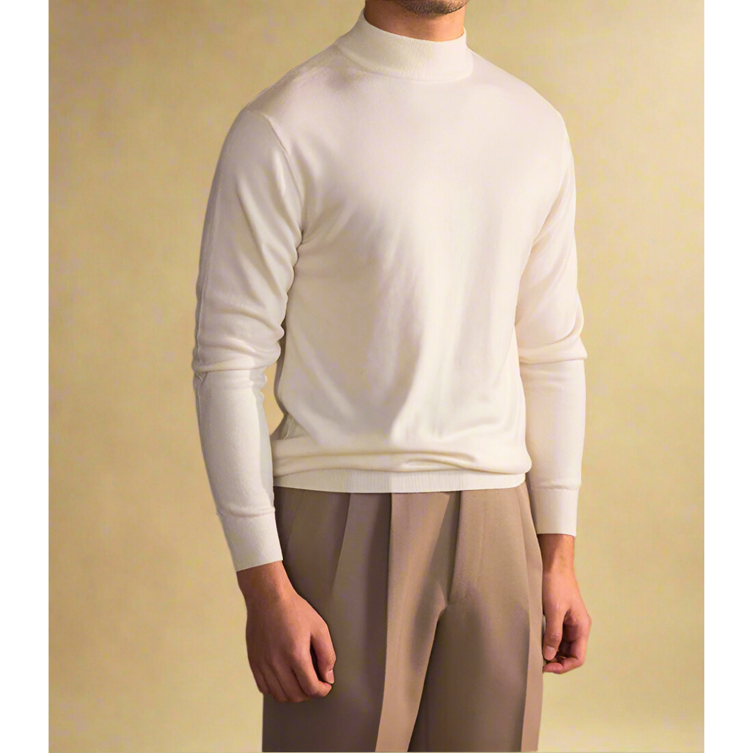 Een man draagt een beige wollen coltrui, belichaamt tijdloze mode en comfort voor elke dag.