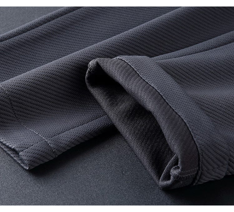 Detailbeeld van het heren Elite trainingspak in zwart/donkerblauw, met opstaande kraag en ritssluiting, flexibel & elegant.