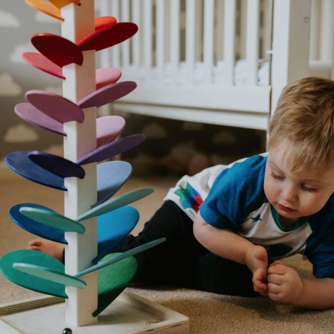 Interactieve houten muziekboom in regenboogkleuren voor kinderspeelgoed, bevordert motoriek en gehoor.