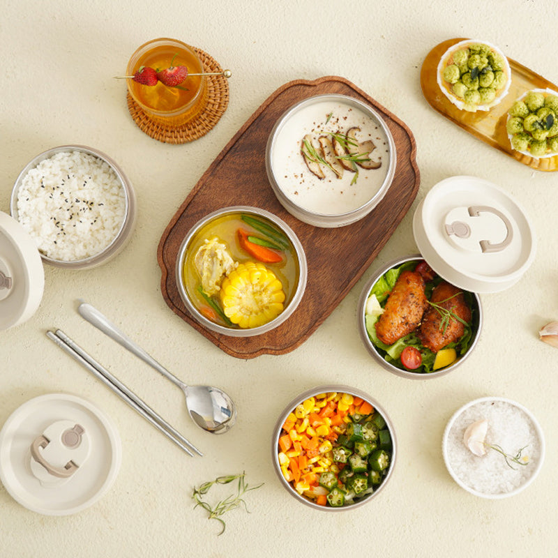 Geïsoleerde meerlaagse lunchbox uit roestvrij staal, rond gestapeld en vooraanzicht, ideaal voor warme gerechten onderweg.