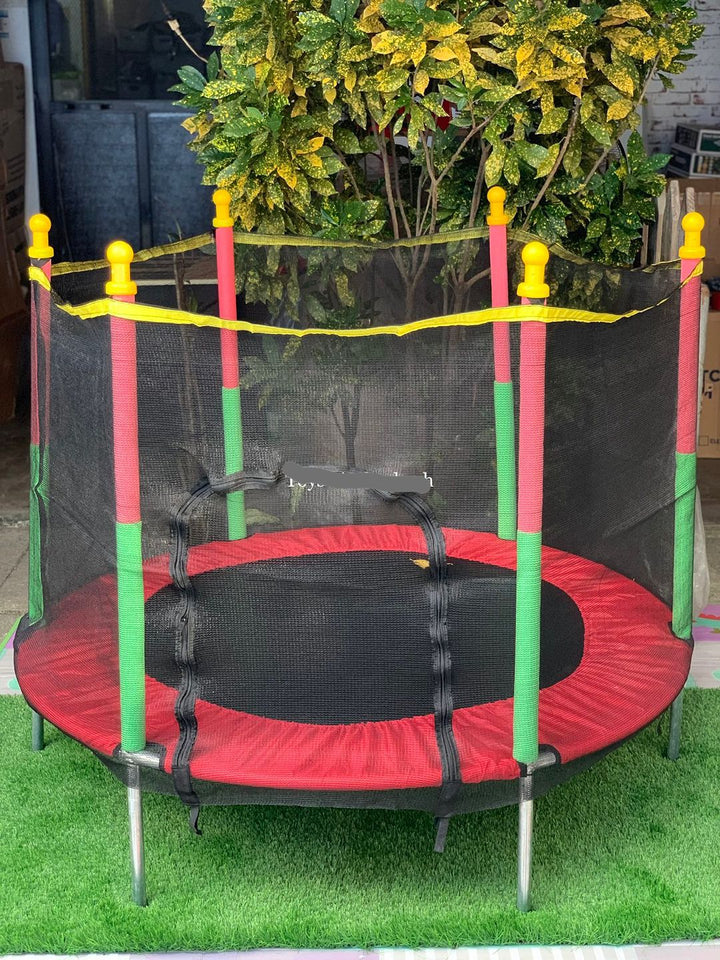 Groene kindertrampoline met veiligheidsnet, ideaal speelgoed voor buitenspelen en beweging in de tuin.