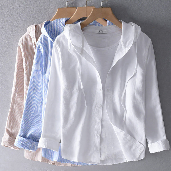 Model draagt een klassieke, ademende katoenen blouse met een elegante snit in lichtblauw, perfect voor warme dagen.