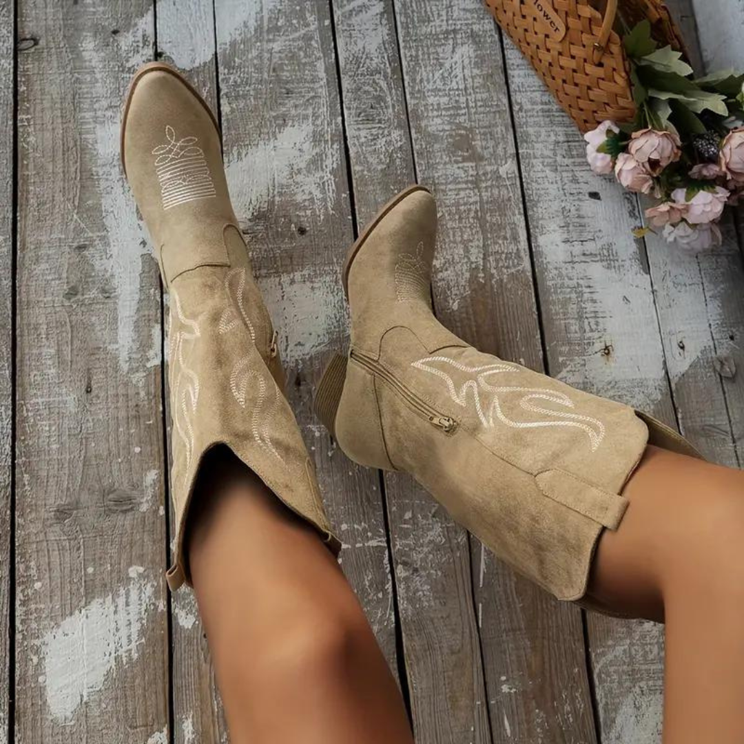 Kniehoge dames cowboylaarzen met spitse neus, vintage charme en robuuste hak in zandkleurige uitvoering.
