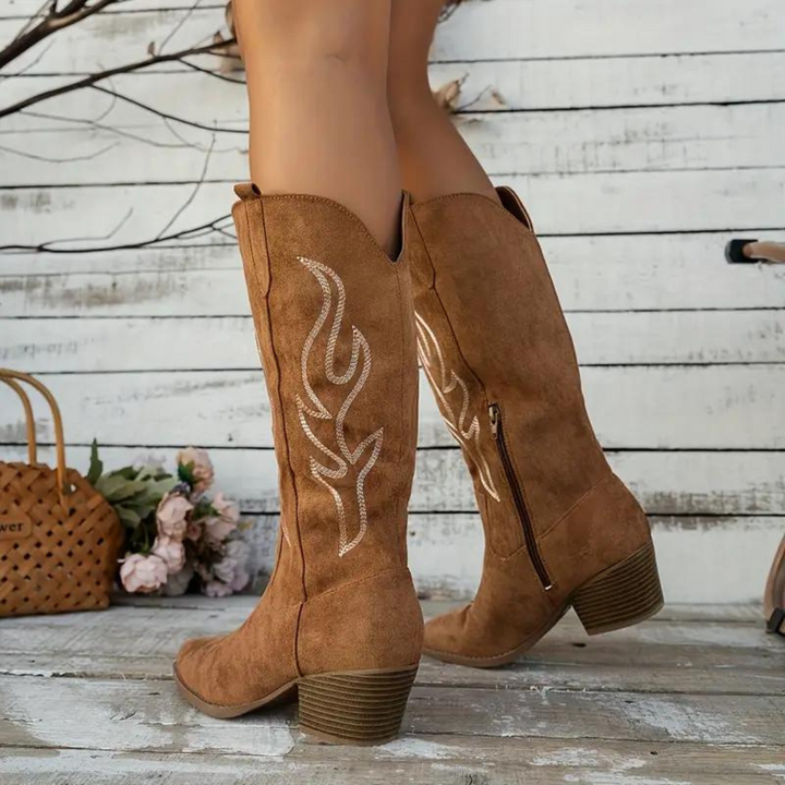 Kniehoge dames cowboylaarzen met spitse neus, vintage charme en robuuste hak in zandkleurige uitvoering.