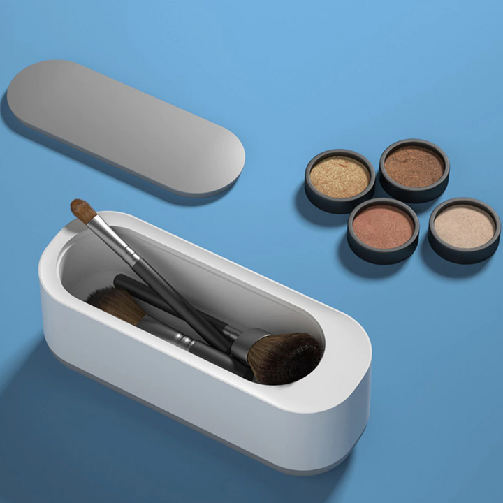 Compacte witte ultrasoonreiniger, ideaal voor 360° reiniging van sieraden en brillen; efficiënte technologie voor thuis.