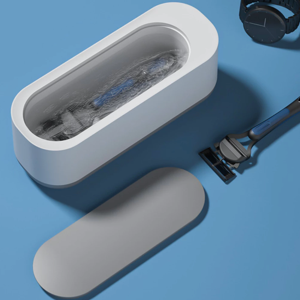Compacte witte ultrasoonreiniger, ideaal voor 360° reiniging van sieraden en brillen; efficiënte technologie voor thuis.