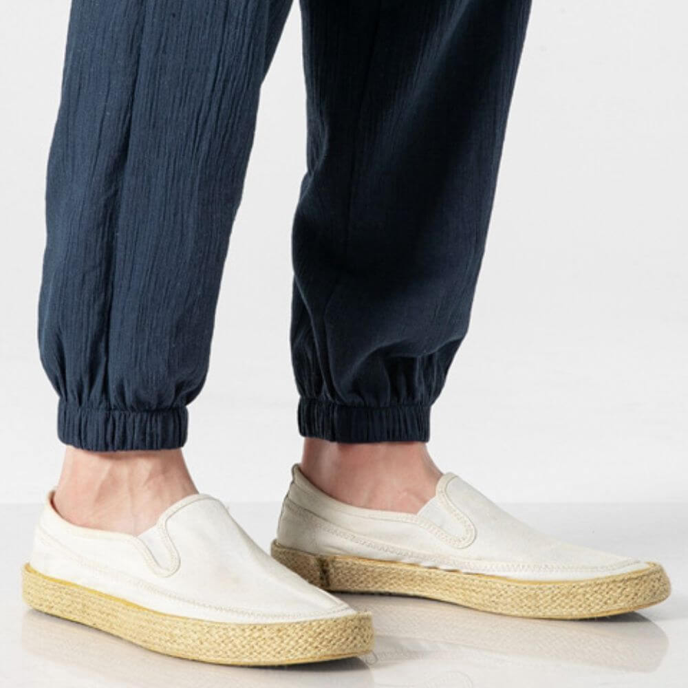 Details van de katoenen en linnen broek voor heren, toont stof en afwerking in verschillende kleuren.