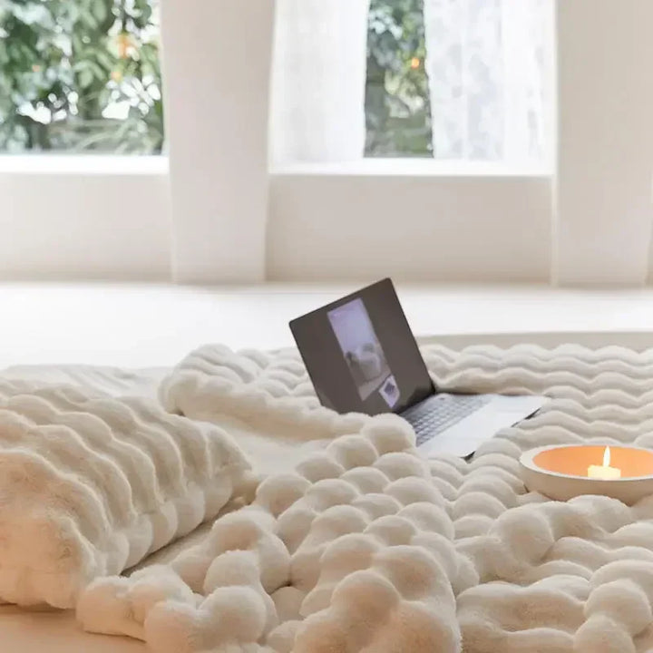 Gezellige WarmWol bankdeken van pluche op een moderne bank; biedt warmte en comfort.