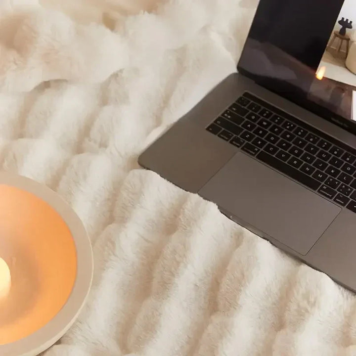 Mooie stapel pluche comfortdekens van WarmWol in verschillende kleuren en maten.
