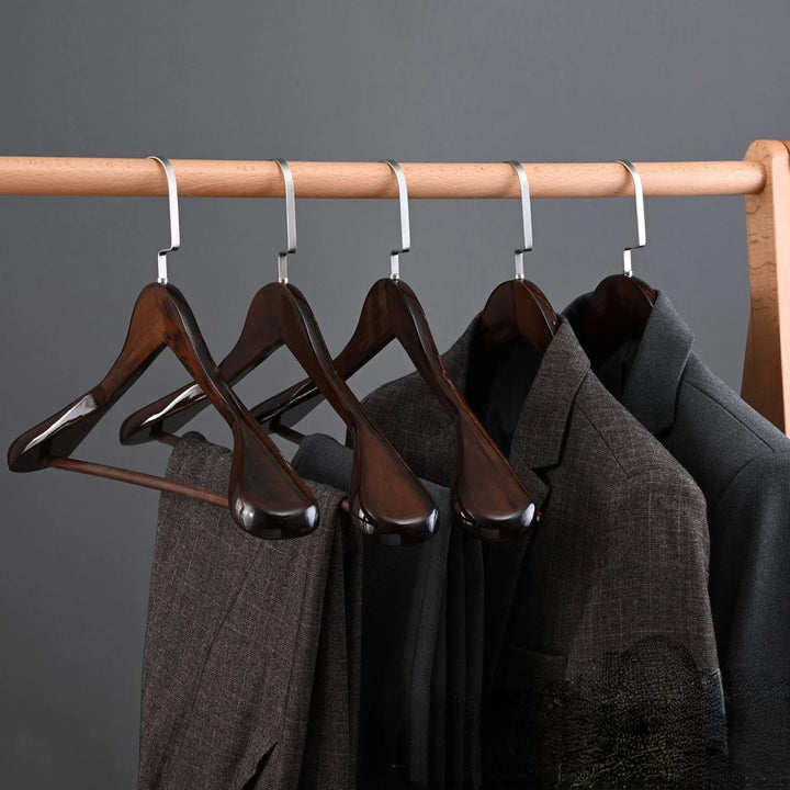 Luxe houten kledinghangers met elegante metalen accenten, elegant gebogen design, hoogwaardig afgewerkt.