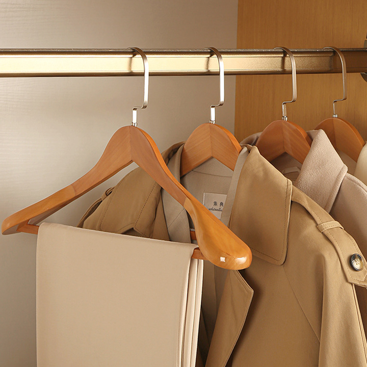 Luxe houten kledinghangers met elegante metalen accenten, elegant gebogen design, hoogwaardig afgewerkt.