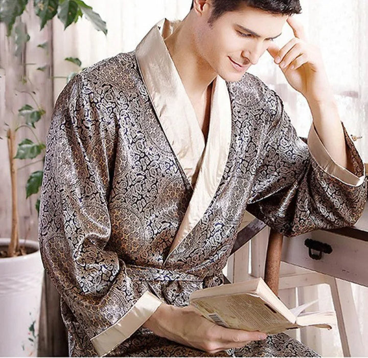 Luxe satijnen damesbadjas met verfijnde goudprint en elegante gouden versieringen op glanzende stof.