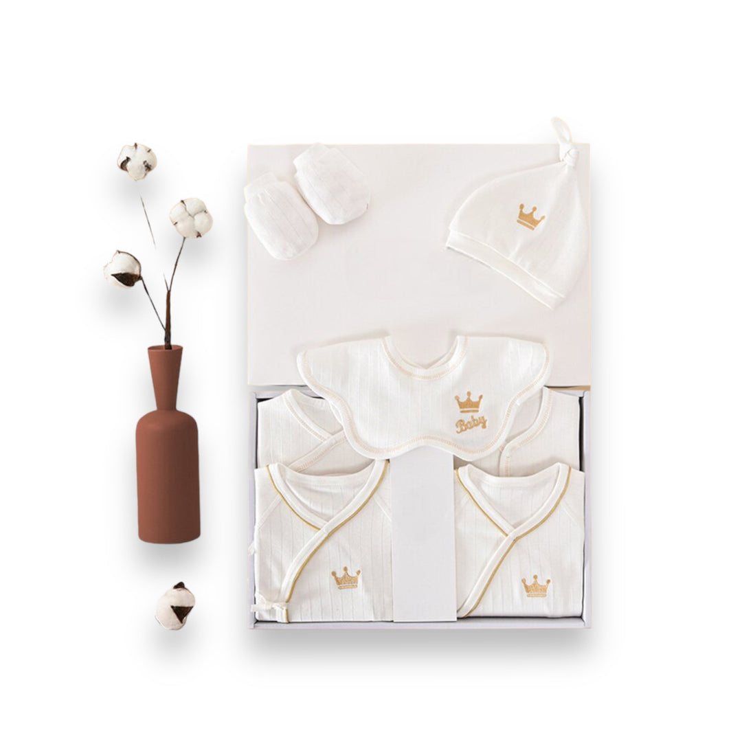 Luxe geschenkset voor pasgeborenen met zachte rompertjes, knusse dekens en schattige accessoires in pastelkleuren.