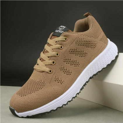 Moderne ademende dames sneaker in witgrijs, van de zijkant gezien met vetersluiting, ideaal voor vrije tijd en sport.