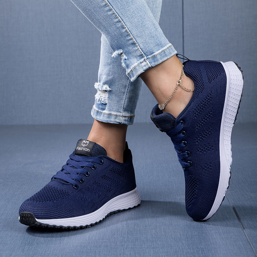 Moderne ademende dames sneaker in witgrijs, van de zijkant gezien met vetersluiting, ideaal voor vrije tijd en sport.