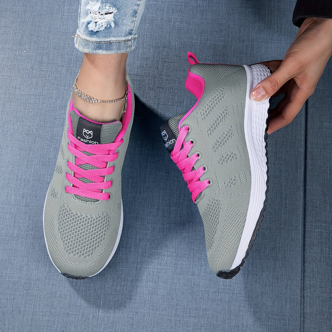 Moderne ademende dames sneaker in witgrijs, van de zijkant gezien met vetersluiting, ideaal voor vrije tijd en sport.
