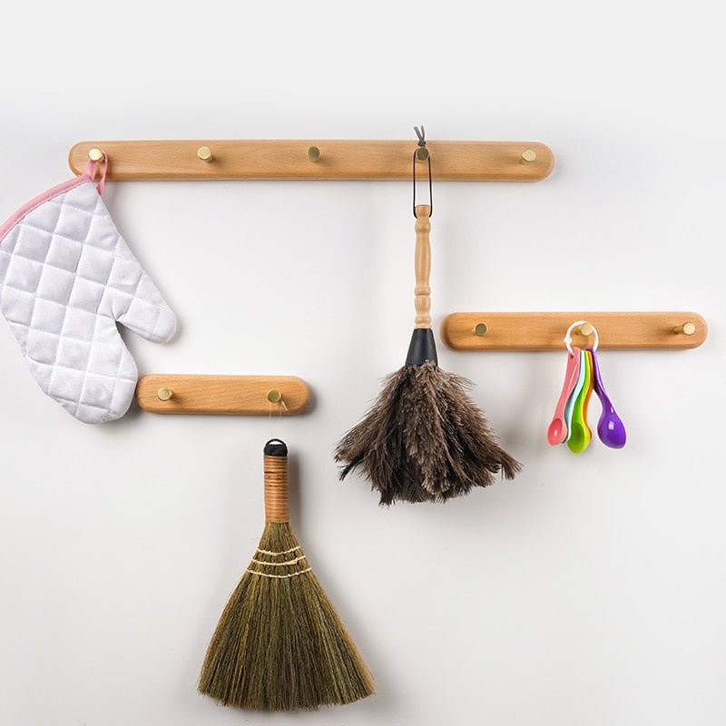 Houten kapstok met minimalistische messing haken. Functioneel en modern design voor een opgeruimde hal of slaapkamer.