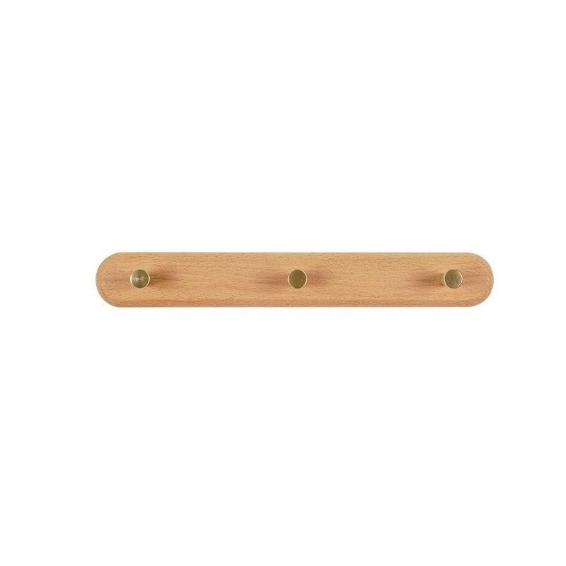 Moderne LignaHook houten wandkapstok, gezien vanuit een interieurhoek. Strak design met messing accenten.