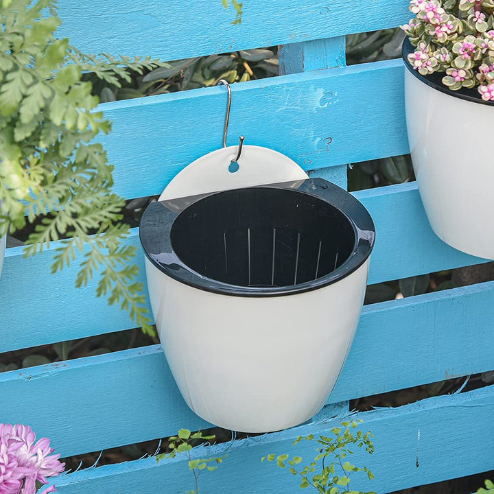 Moderne witte hangende plantenbak met zelfirrigatie voor binnen en buiten, ruimtebesparend en decoratief.