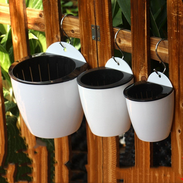 Moderne witte hangende plantenbak met zelfirrigatie voor binnen en buiten, ruimtebesparend en decoratief.