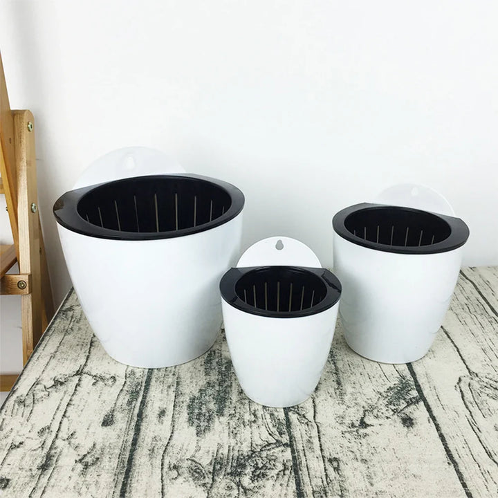 Moderne witte hangende plantenbak met zelfirrigatie voor binnen en buiten, ruimtebesparend en decoratief.