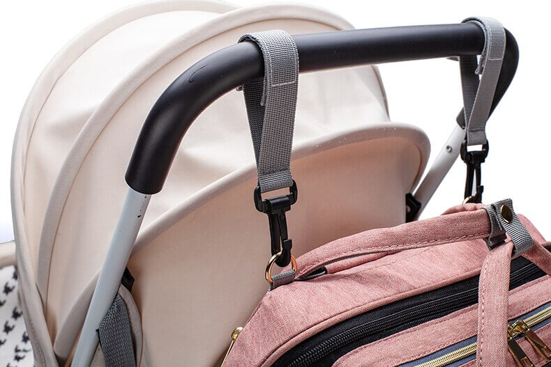 Comfortabele en georganiseerde luiertas-rugzak met draagbaar babybedje voor reizende ouders.