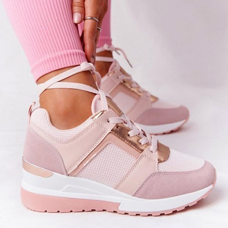 Witte orthopedische damessneakers, gedragen tijdens het wandelen, tonen flexibiliteit
