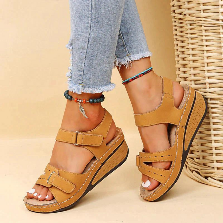 Stijlvolle orthopedische sandalen in beige voor vrouwelijke voeten, close-up van de textuur.