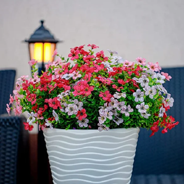 Kleurrijk boeket realistische kunstbloemen in vaas, sfeervolle decoratie voor huis of tuin.