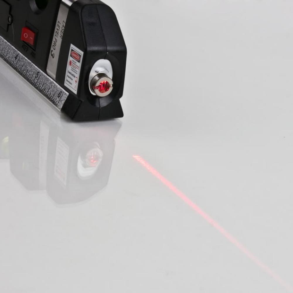 Zwarte multifunctionele laser waterpas met meetlint, libel en laserstraal op een houten achtergrond.