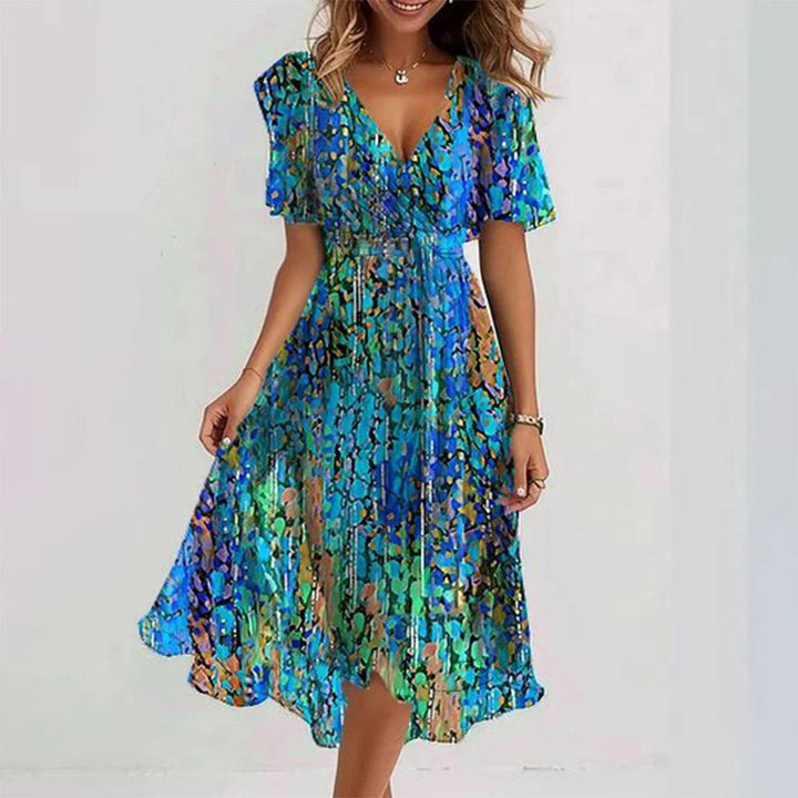Zijaanzicht van de midi-jurk met bloemenprint, elegante pasvorm, comfortabel en veelzijdig.