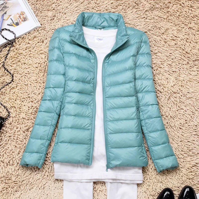 Vooraanzicht van de taupe dames donsjas met capuchon, ultralicht, lange mouwen, ideaal voor koude dagen, draagbaar, stijlvol en isolerend.