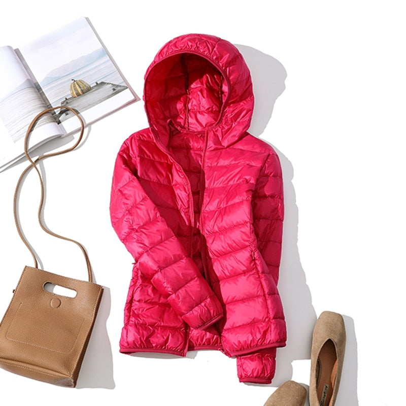 Ultraleichte blaue Damenjacke, wasserabweisend, Stil frontansicht mit verstellbarer Kapuze und praktischen Taschen.