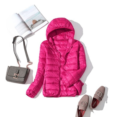 Ultraleichte blaue Damenjacke, wasserabweisend, Stil frontansicht mit verstellbarer Kapuze und praktischen Taschen.