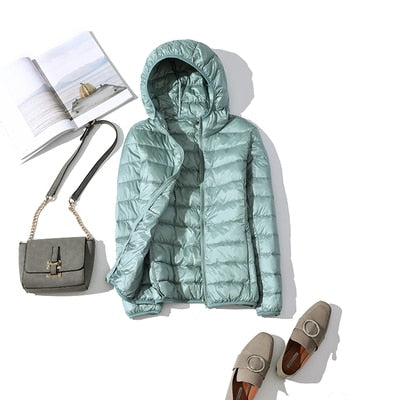 Ultraleichte blaue Damenjacke, wasserabweisend, Stil frontansicht mit verstellbarer Kapuze und praktischen Taschen.