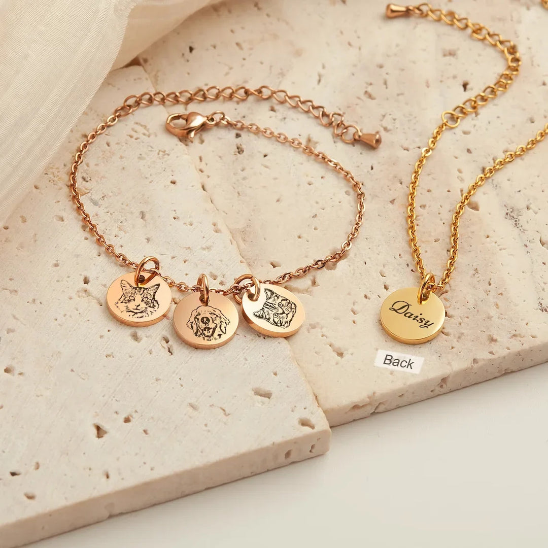 Close-up van een gepersonaliseerde zilveren huisdier armband met gegraveerde naam en pootafdruk, unisex.