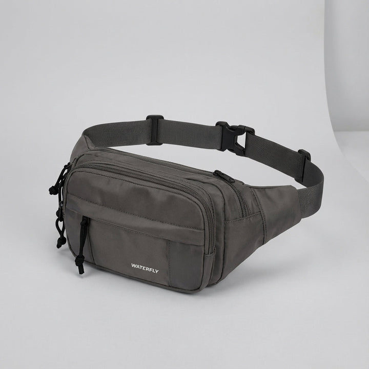 Praktische nylon heuptas met diverse ritsvakken; waterbestendig en comfortabel voor onderweg.