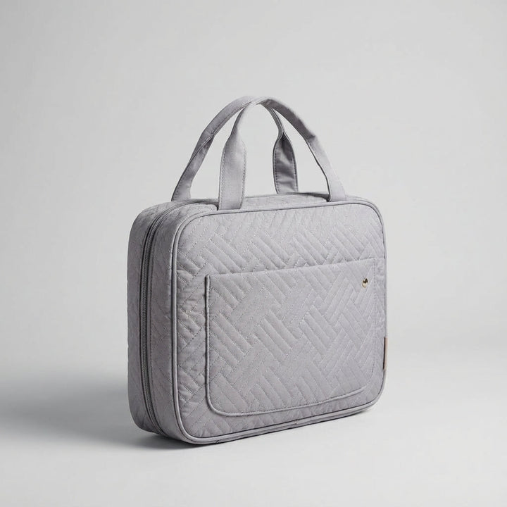 Neatmate reistoilettas naast bagage, een essentieel reisaccessoire voor georganiseerde en zorgeloze vakanties.
