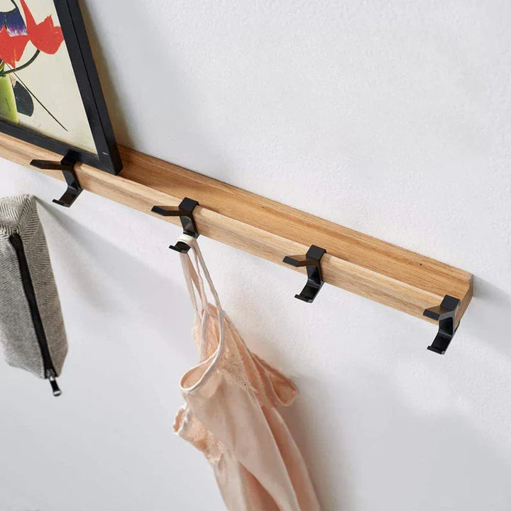 Wandkapstok met beweegbare haken van hout en metaal in scandinavisch design, geschikt voor hal of slaapkamer.