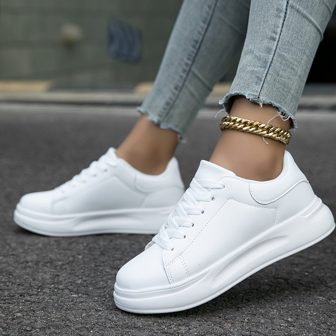Witte dames leren sneakers, stijlvol en orthopedisch, close-up van de zijaanzicht met veters en rubberen zool.