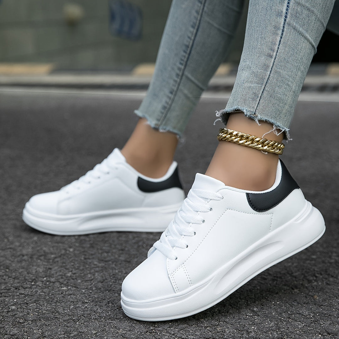Witte dames leren sneakers, stijlvol en orthopedisch, close-up van de zijaanzicht met veters en rubberen zool.
