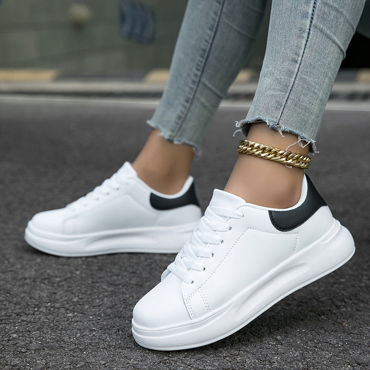 Witte dames leren sneakers, stijlvol en orthopedisch, close-up van de zijaanzicht met veters en rubberen zool.