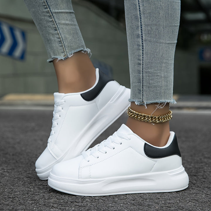 Witte dames leren sneakers, stijlvol en orthopedisch, close-up van de zijaanzicht met veters en rubberen zool.