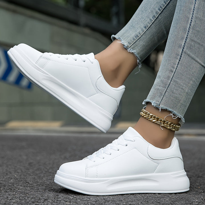 Witte dames leren sneakers, stijlvol en orthopedisch, close-up van de zijaanzicht met veters en rubberen zool.