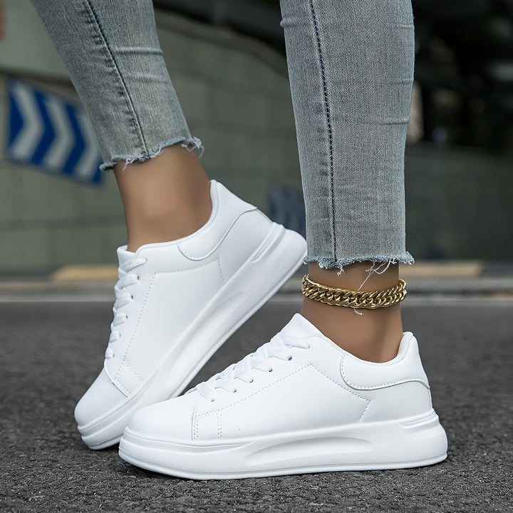 Witte dames leren sneakers, stijlvol en orthopedisch, close-up van de zijaanzicht met veters en rubberen zool.