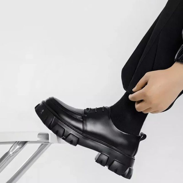 Gedetailleerde foto van zwarte leren herenschoenen, nette afwerking en dikke comfortabele zool.