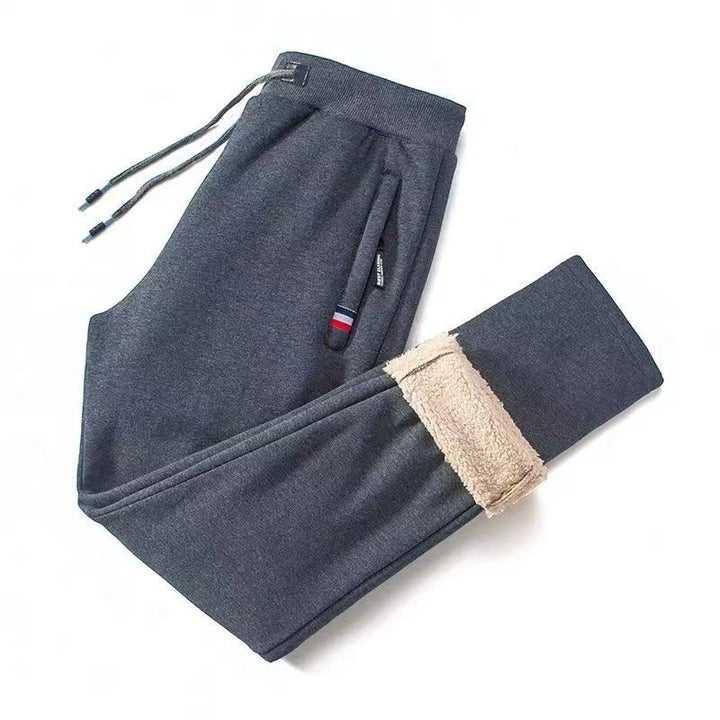 Man draagt zwarte thermobroek tijdens wintersport. Warme fleecebroek voor outdoor kleding en sportieve activiteiten.