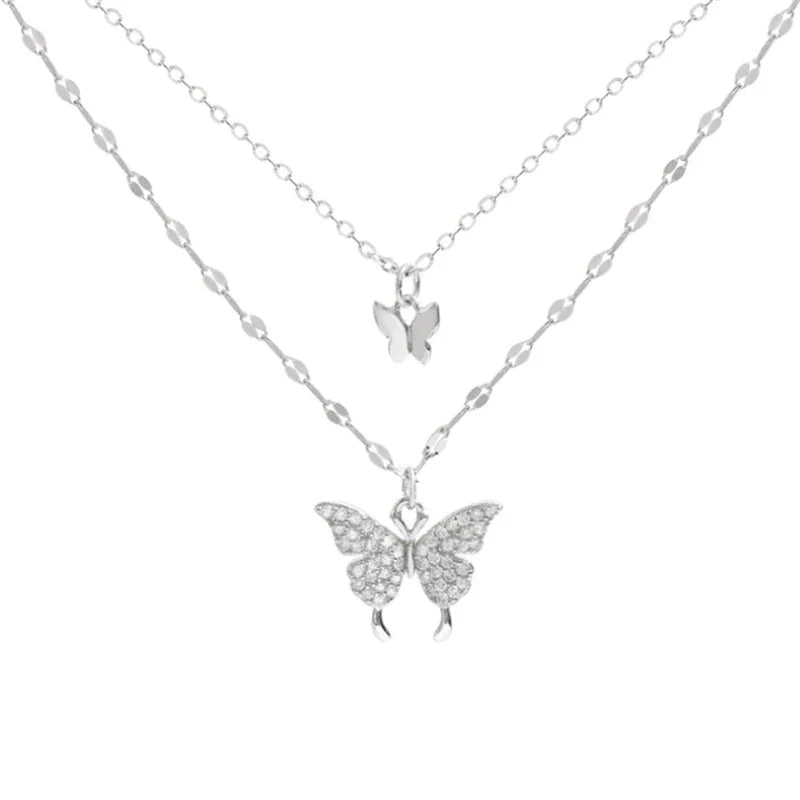 Duo-laags zilveren ketting met vlinderhanger en sprankelende zirkoniastenen, elegant en natuur-geïnspireerd sieraadontwerp.